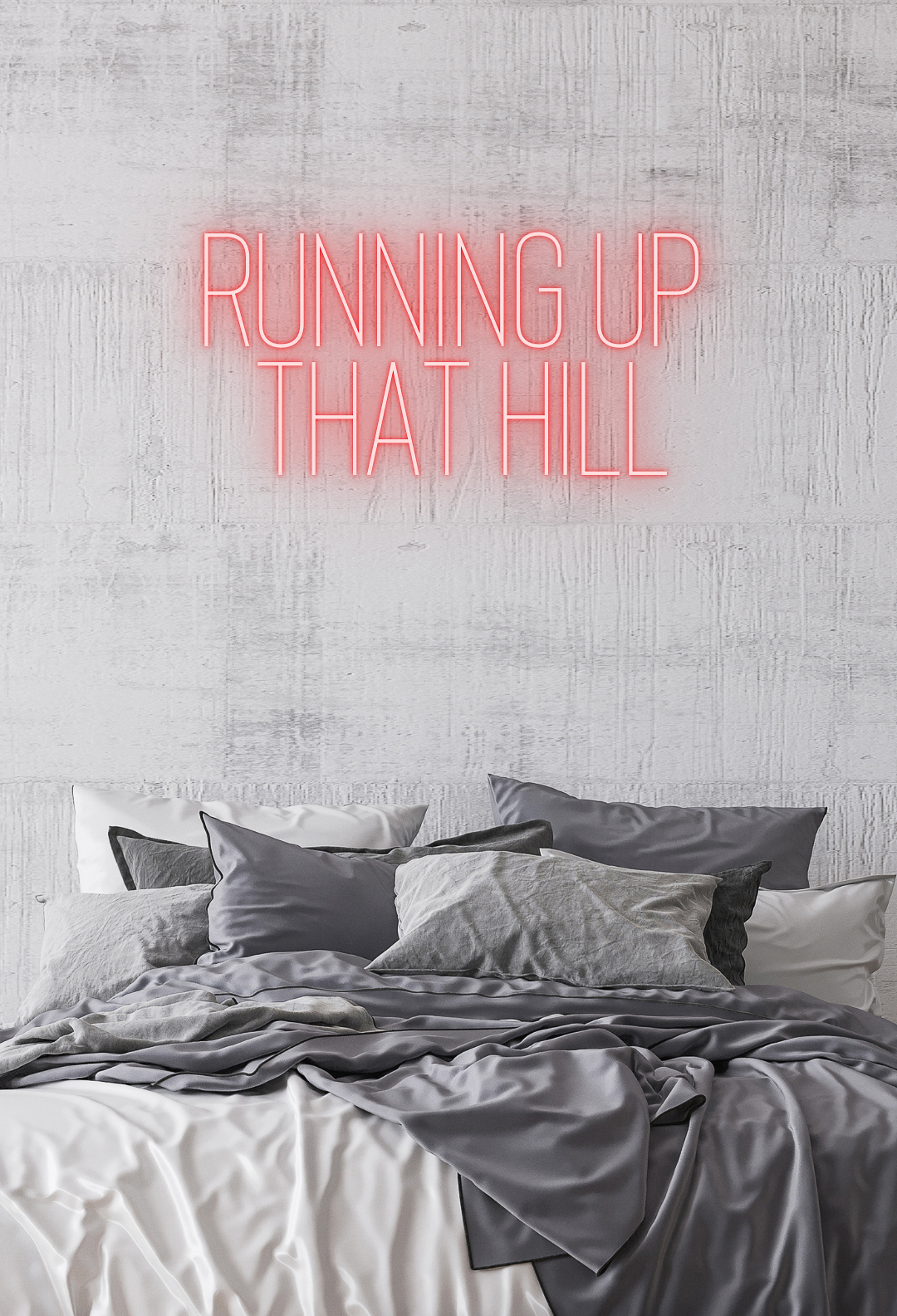 Grey concrete wall with a double bed in centre, fitted with grey bedding. There is a Stranger Things LED neon sign mockup above the bed, reading 'running up that hill' in capital letters and red LED.