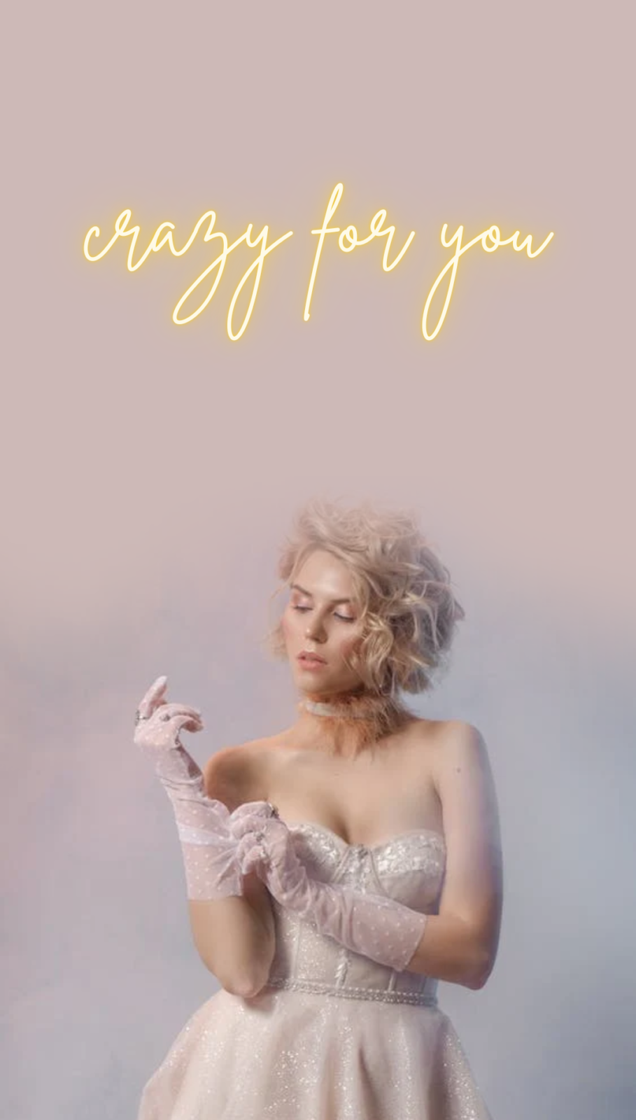 Neon sign ideas for a retro wedding - image shows young woman dressed in a trendy 80s Madonna inspired wedding dress, with sheer white polka dot gloves to match. There is a warm white neon sign mockup above the woman's head reading 'crazy for you' in a script font.