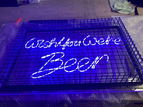neon signs for bars - blue caged faux neon sign reading 'wish you were beer' in a script font 