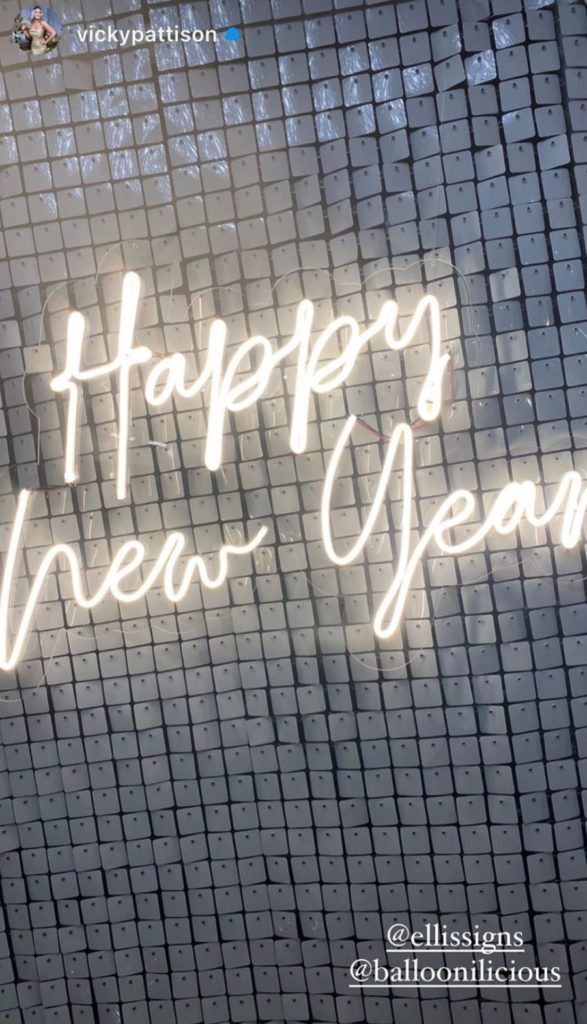 Warm white happy new year neon sign against a silver sequin backdrop for Vicky Pattison's NYE party