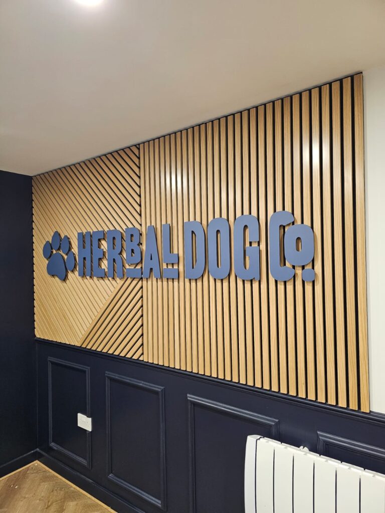 Herbal Dog Co wood slat wall with blue acrylic lettering